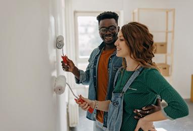 Young couple painting the walls of their new home